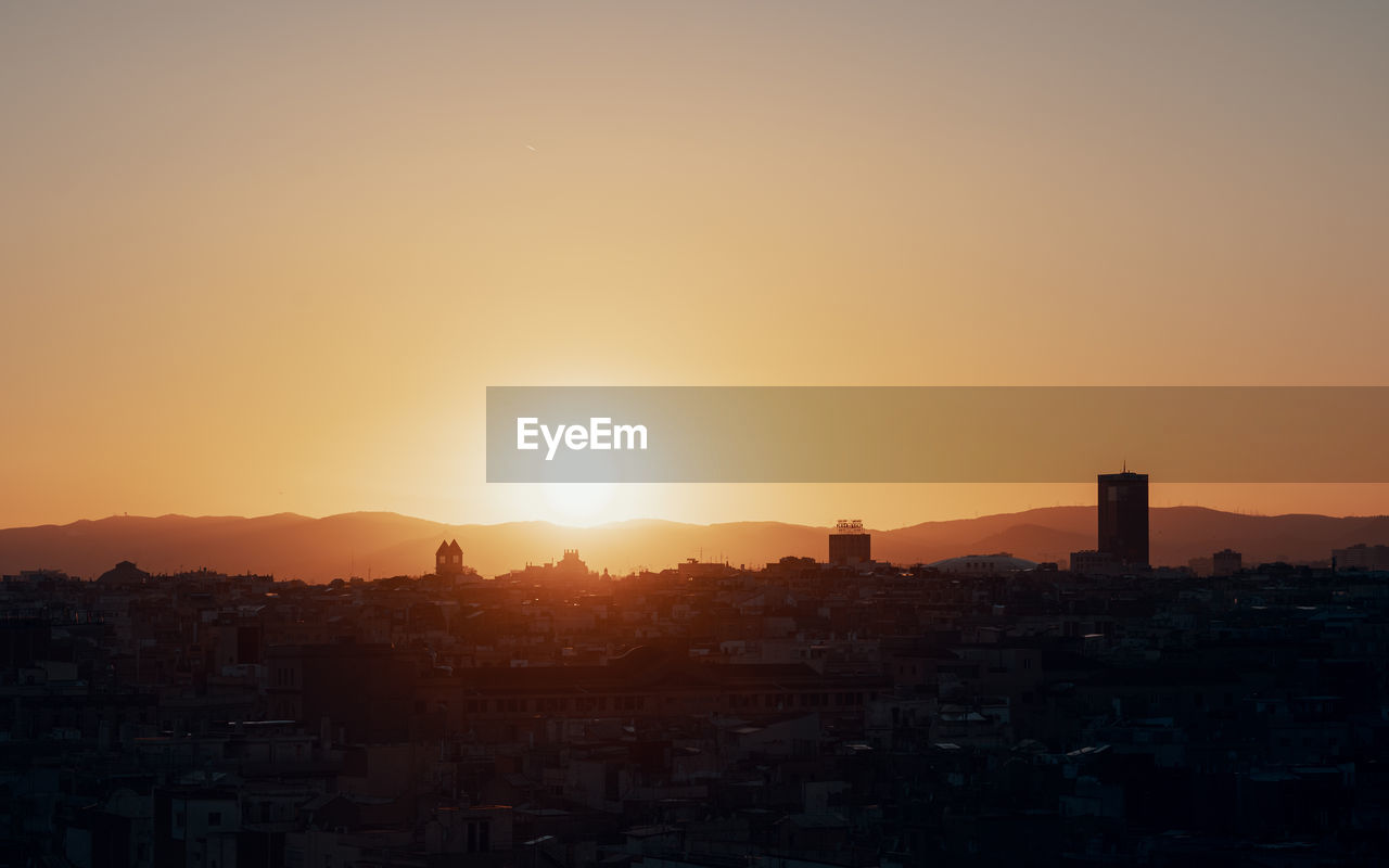 Cityscape against clear sky during sunset