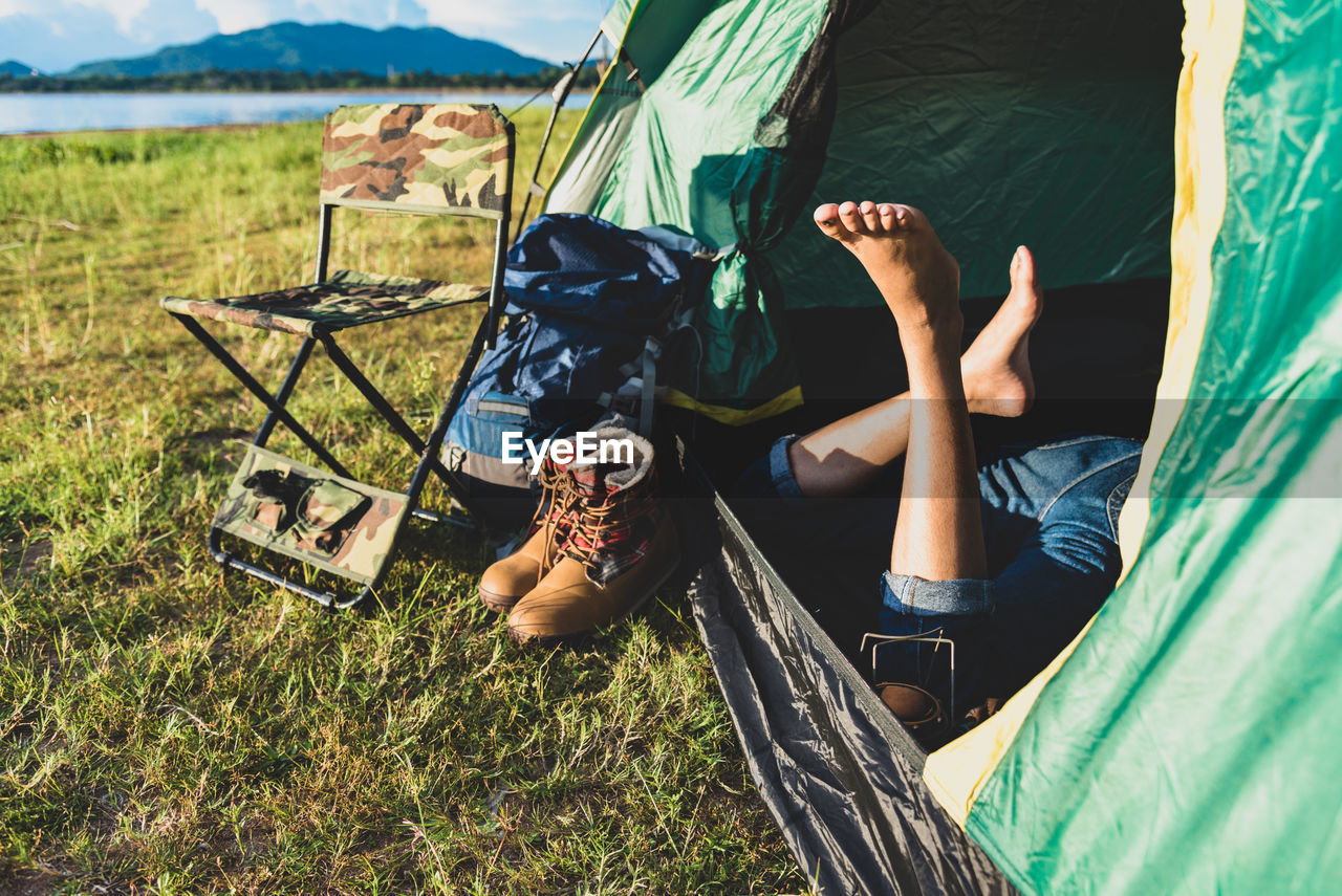 Low section of woman relaxing in tent