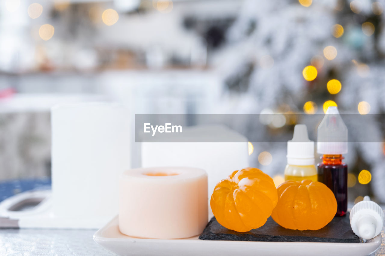 food and drink, yellow, food, table, no people, meal, celebration, focus on foreground, healthy eating, fruit, lighting, candle, container, drink, decoration, indoors, nature, freshness, bottle, orange color