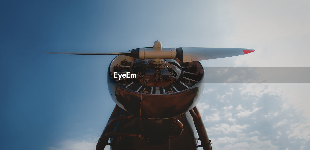 Low angle view of clock on airplane against sky