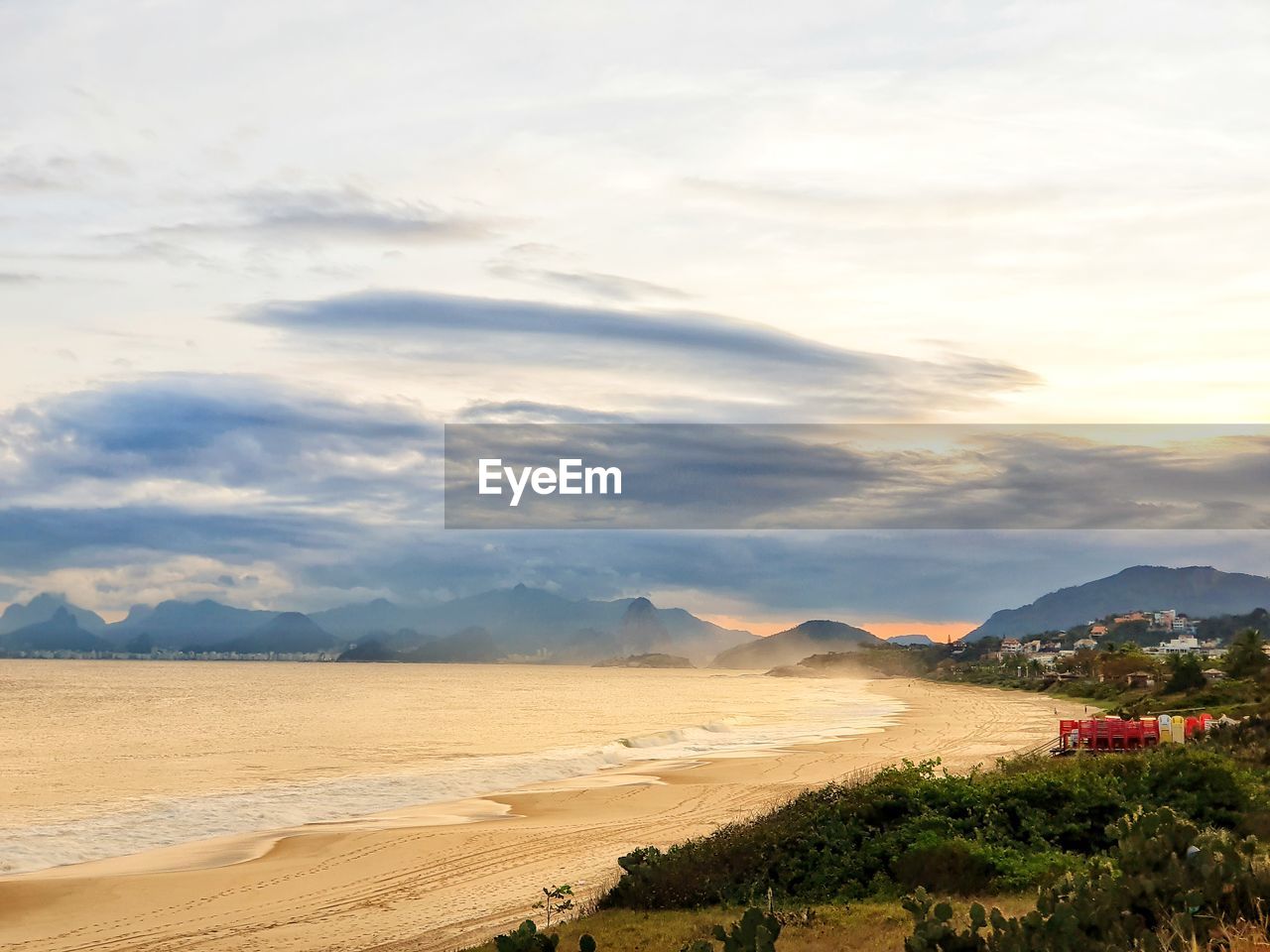 SCENIC VIEW OF BEACH AGAINST CLOUDY SKY