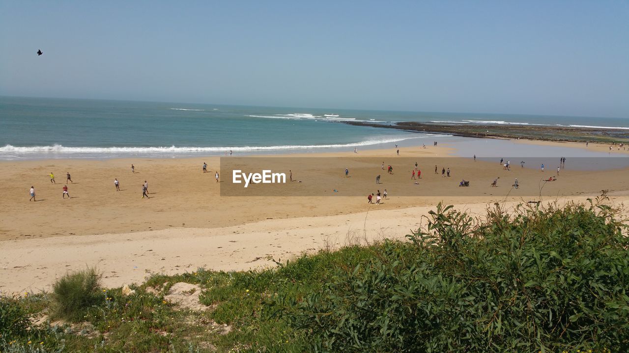 PEOPLE ON BEACH AGAINST SKY