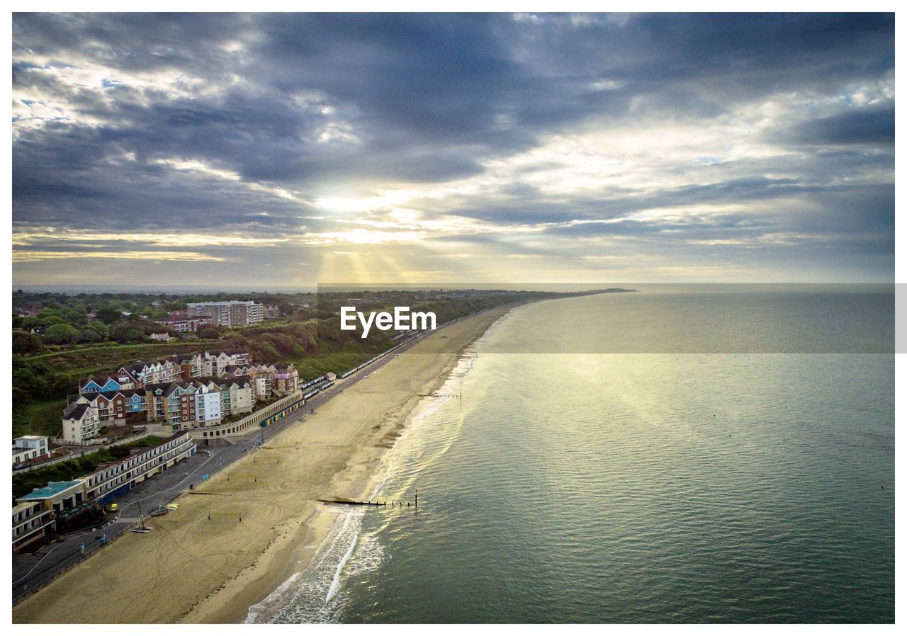 Aerial view of city by sea against sky