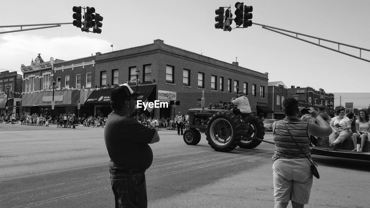 PEOPLE STANDING ON ROAD AGAINST SKY