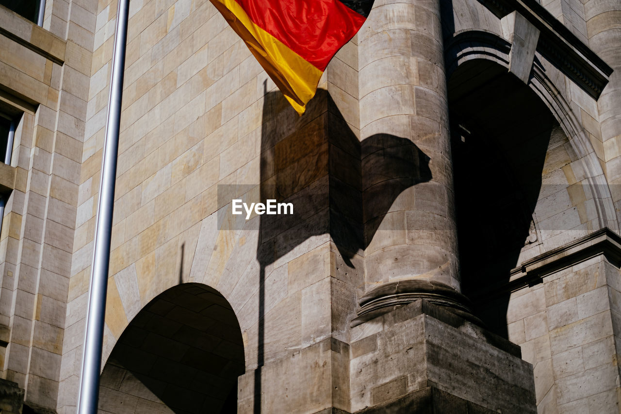 Low angle view of german flag waving against building