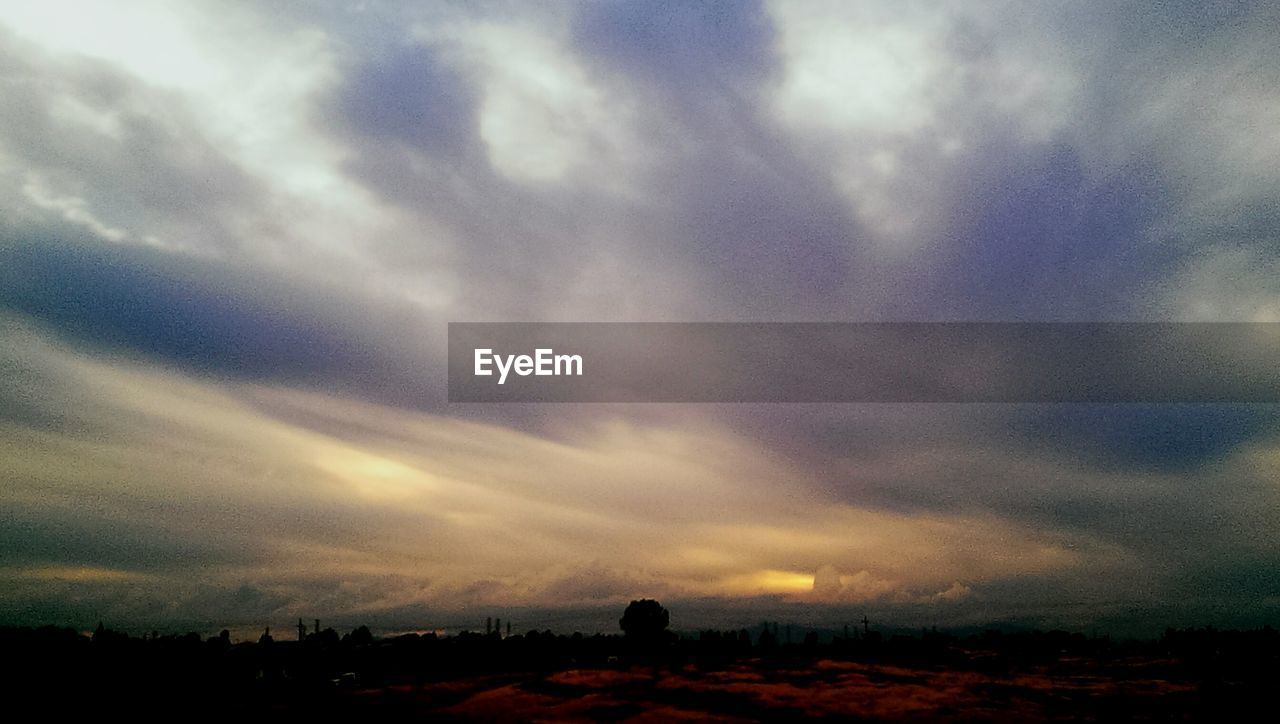 SCENIC VIEW OF LANDSCAPE AGAINST CLOUDY SKY AT SUNSET