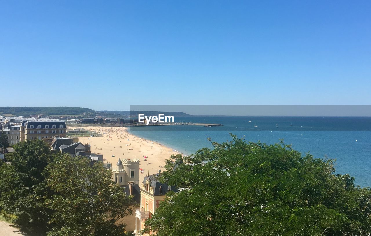 Scenic view of sea and coastline against clear and blue sky 