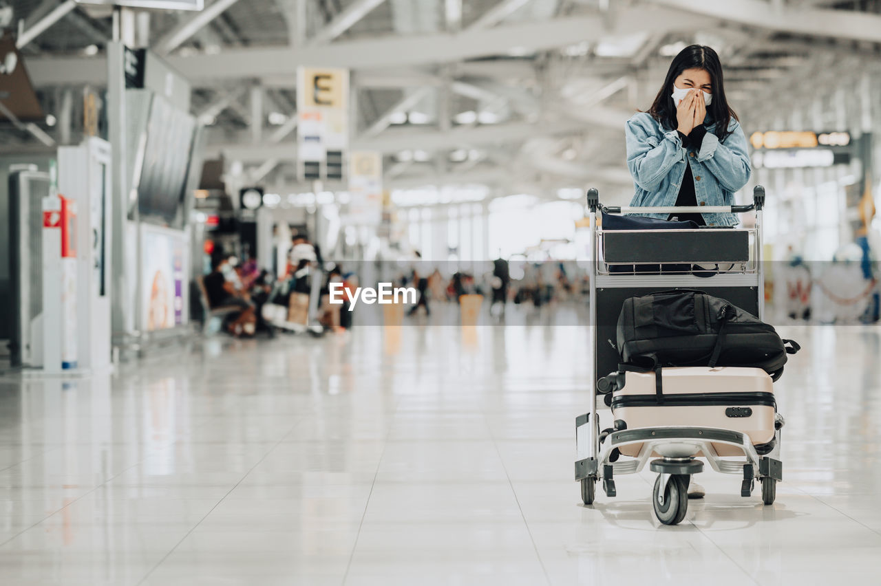 Full length of woman sitting at airport