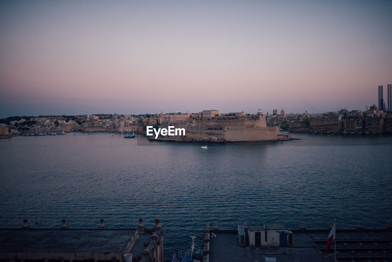 BUILDINGS BY SEA AGAINST CLEAR SKY