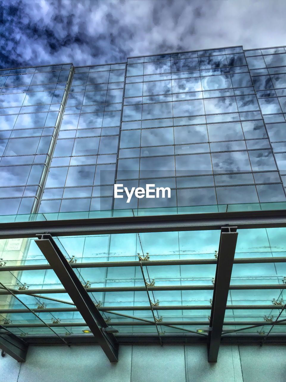 LOW ANGLE VIEW OF MODERN BUILDING AGAINST CLOUDY SKY