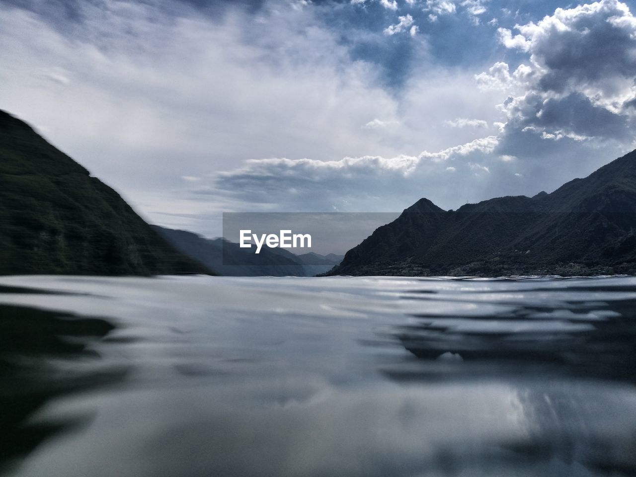 Scenic view of lake by mountains against sky