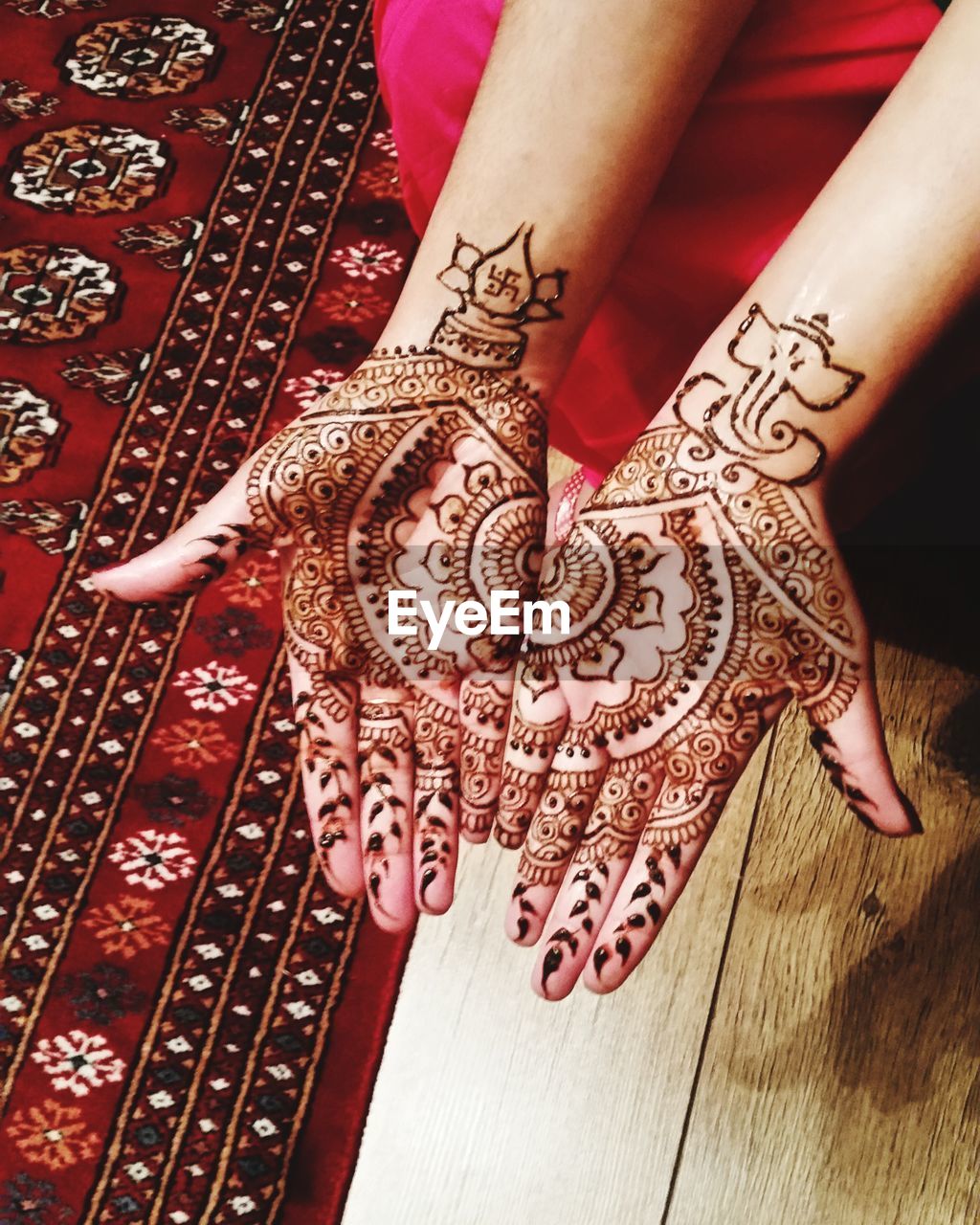 CLOSE-UP OF WOMAN HAND WITH TEXT PAINTING ON CARPET