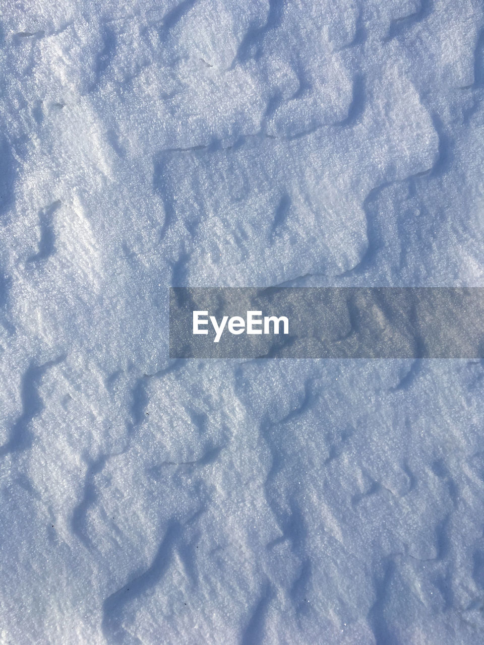 CLOSE-UP OF SNOW ON ASPHALT