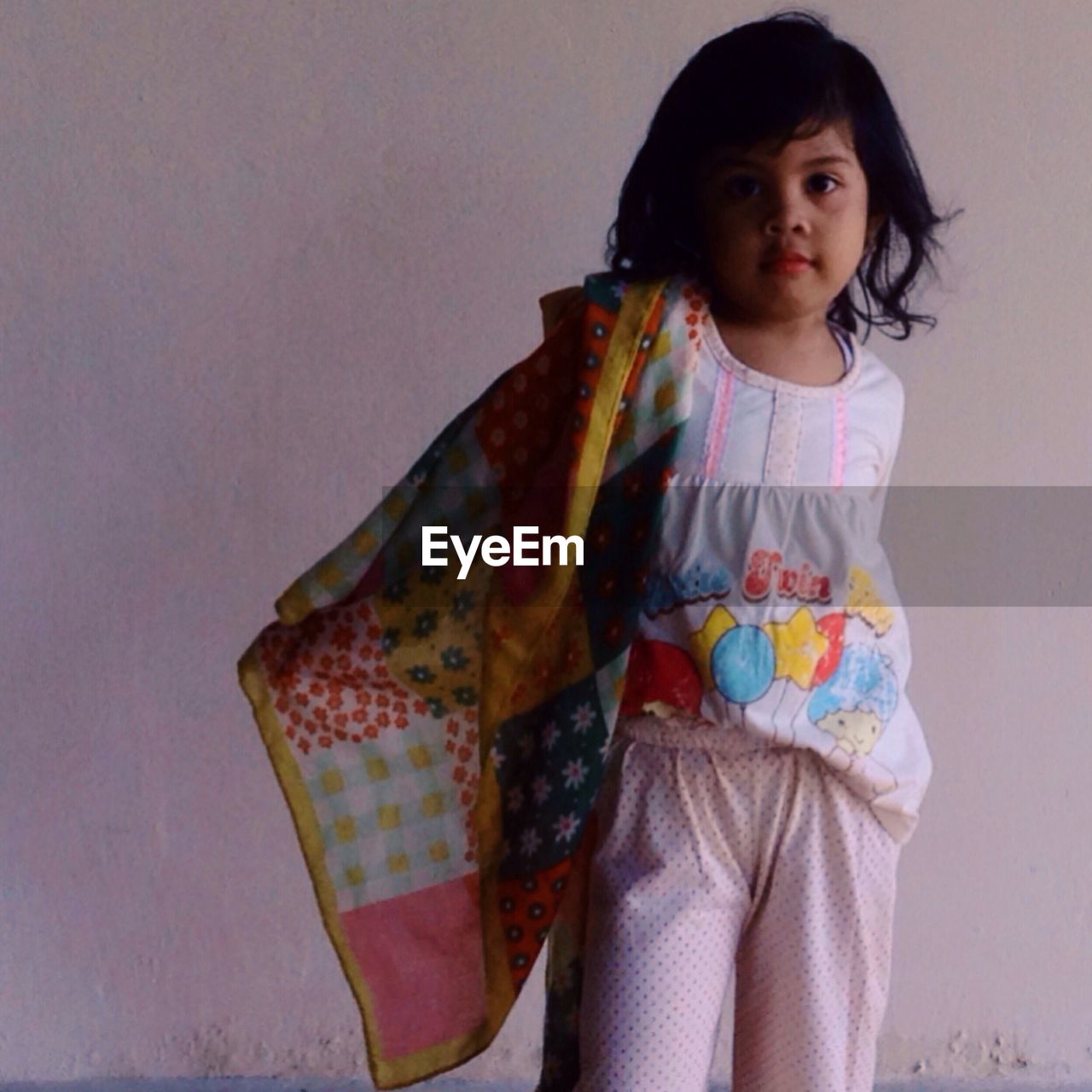 Portrait of girl standing against wall