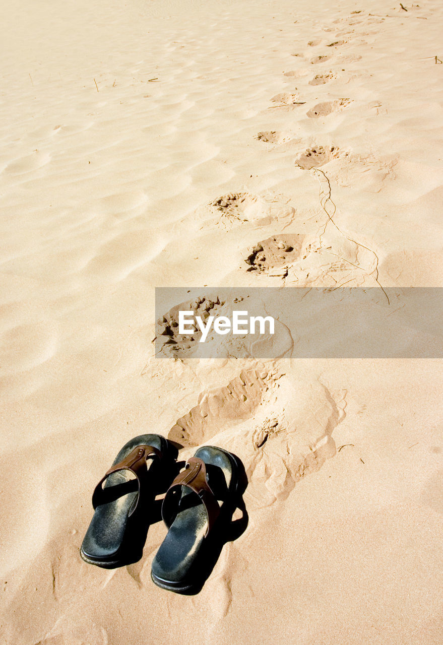 High angle view of shoes on sand at beach