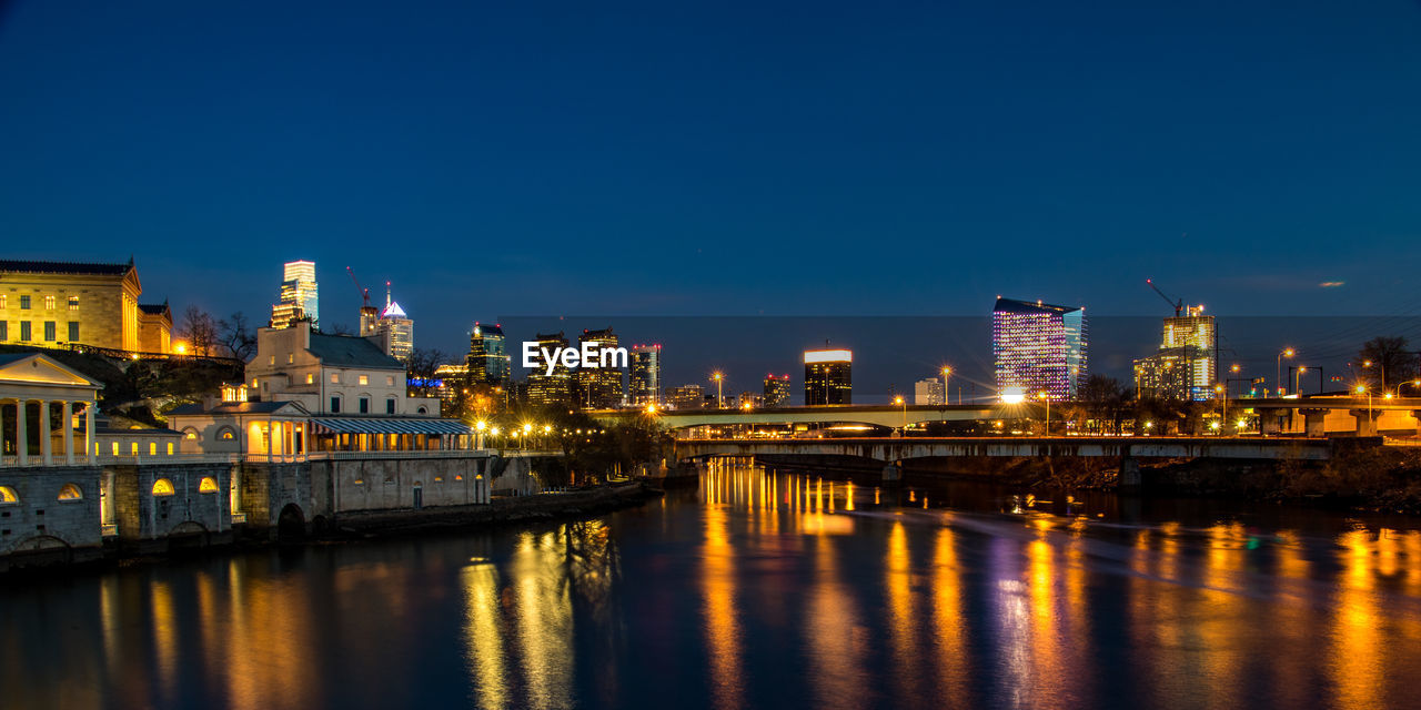 Illuminated buildings against clear sky at night