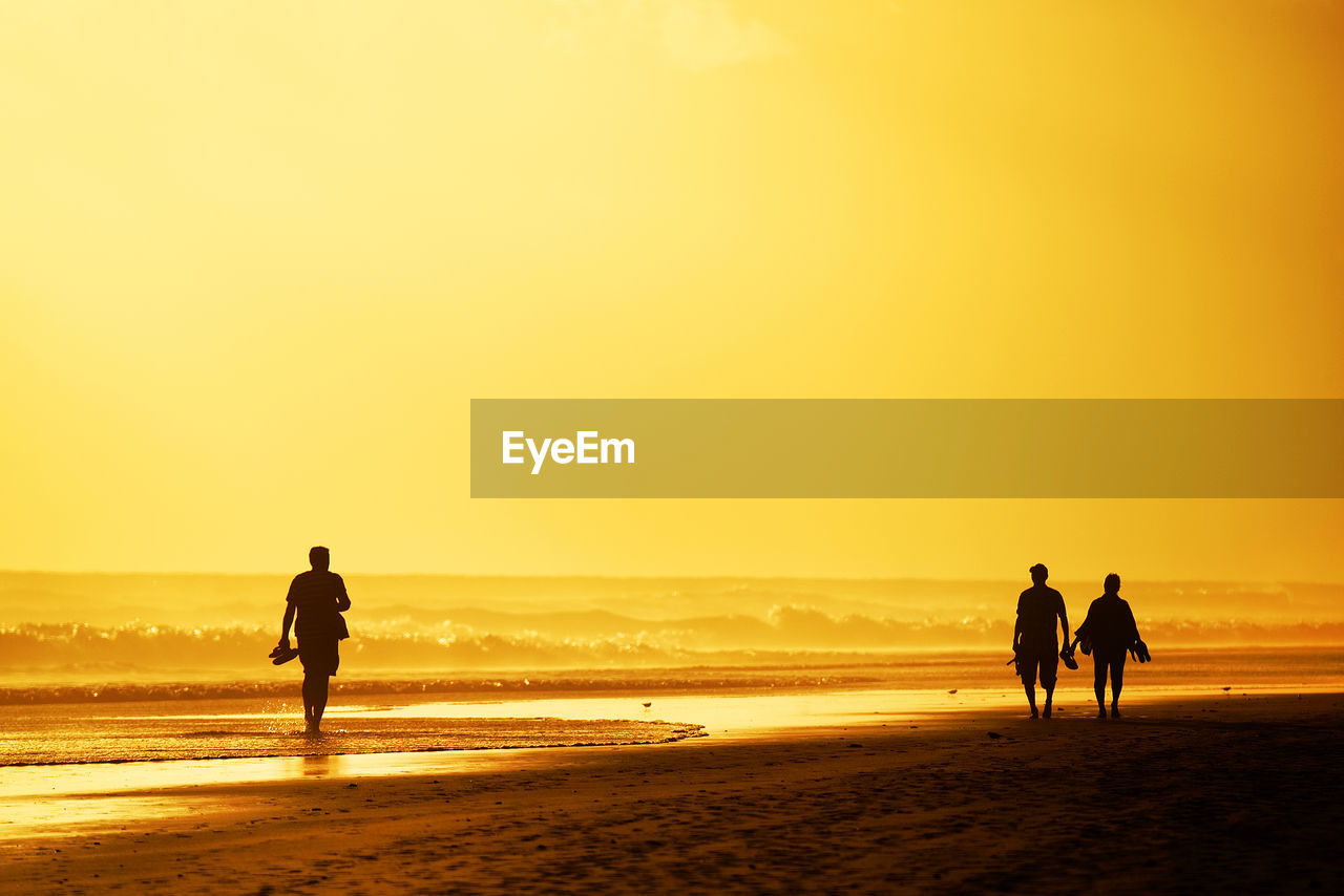 Tourists visiting beach against sky