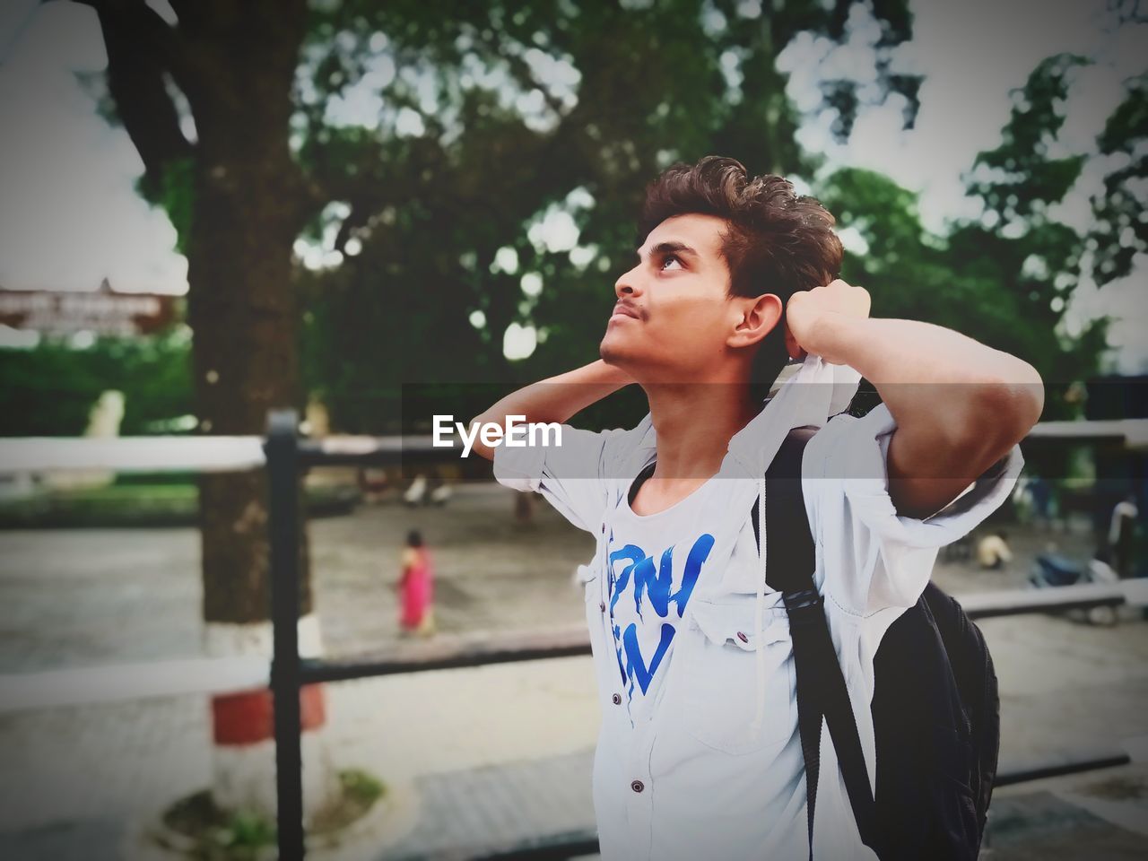 Teenage boy looking up while standing outdoors