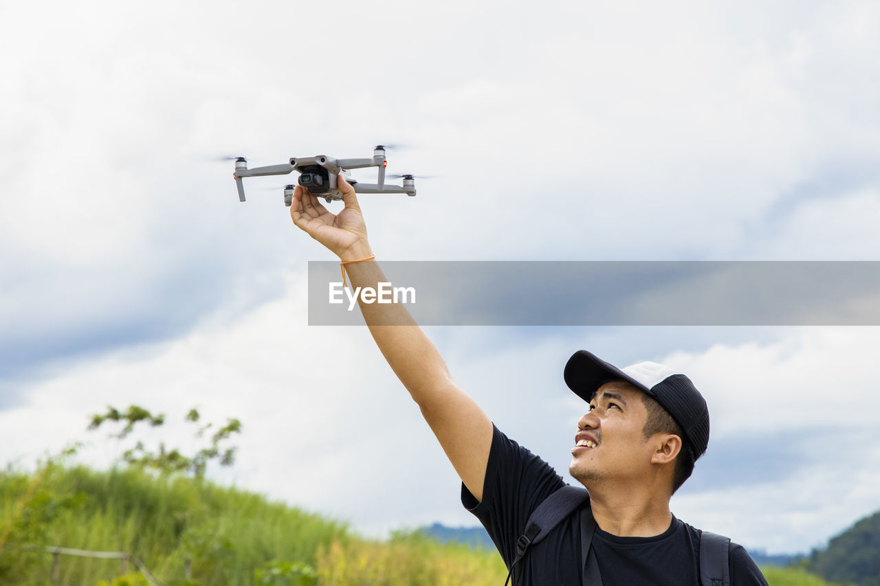 Smiling man holding drone outdoors