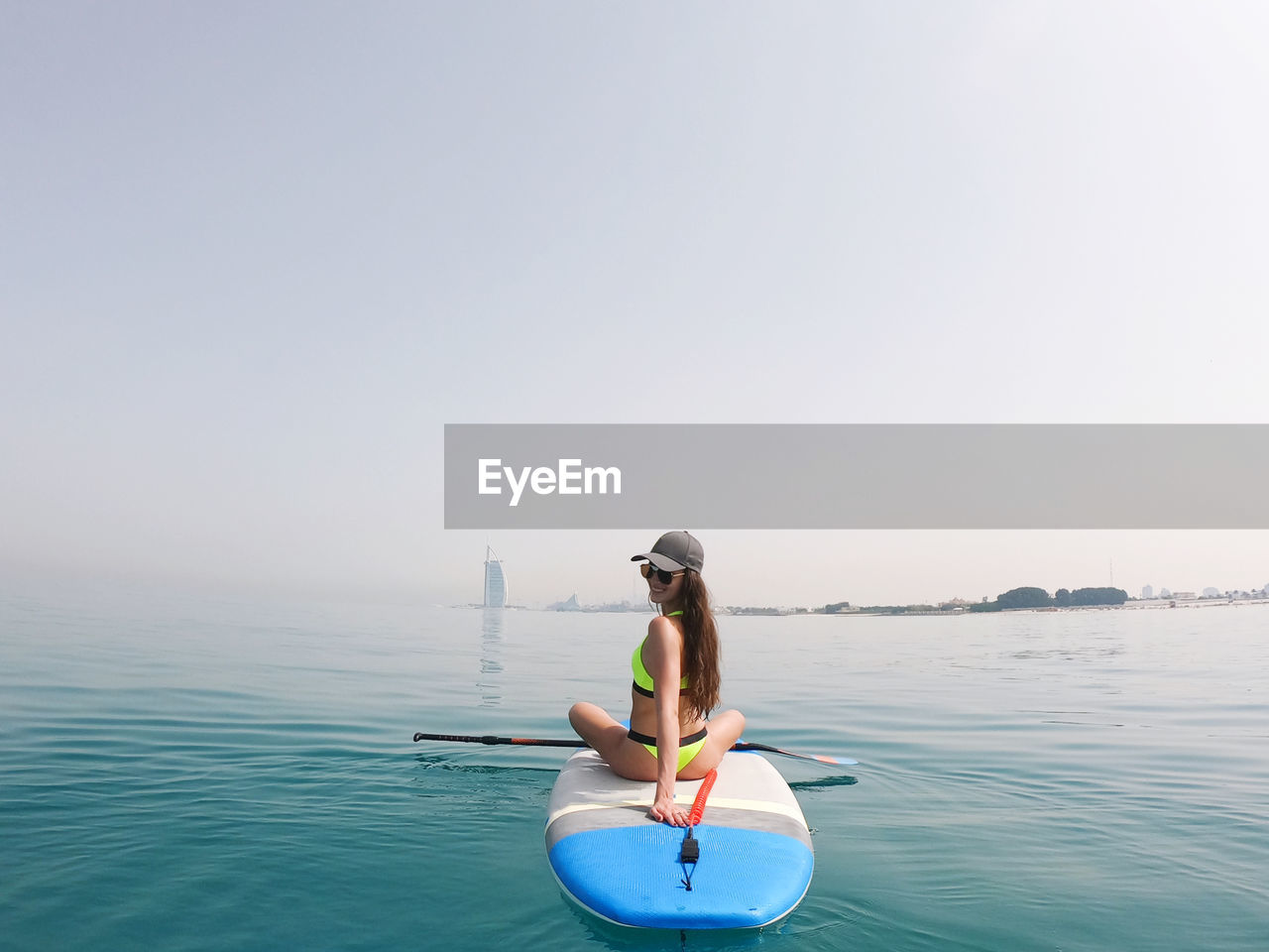 Young woman paddle boarding in dubai