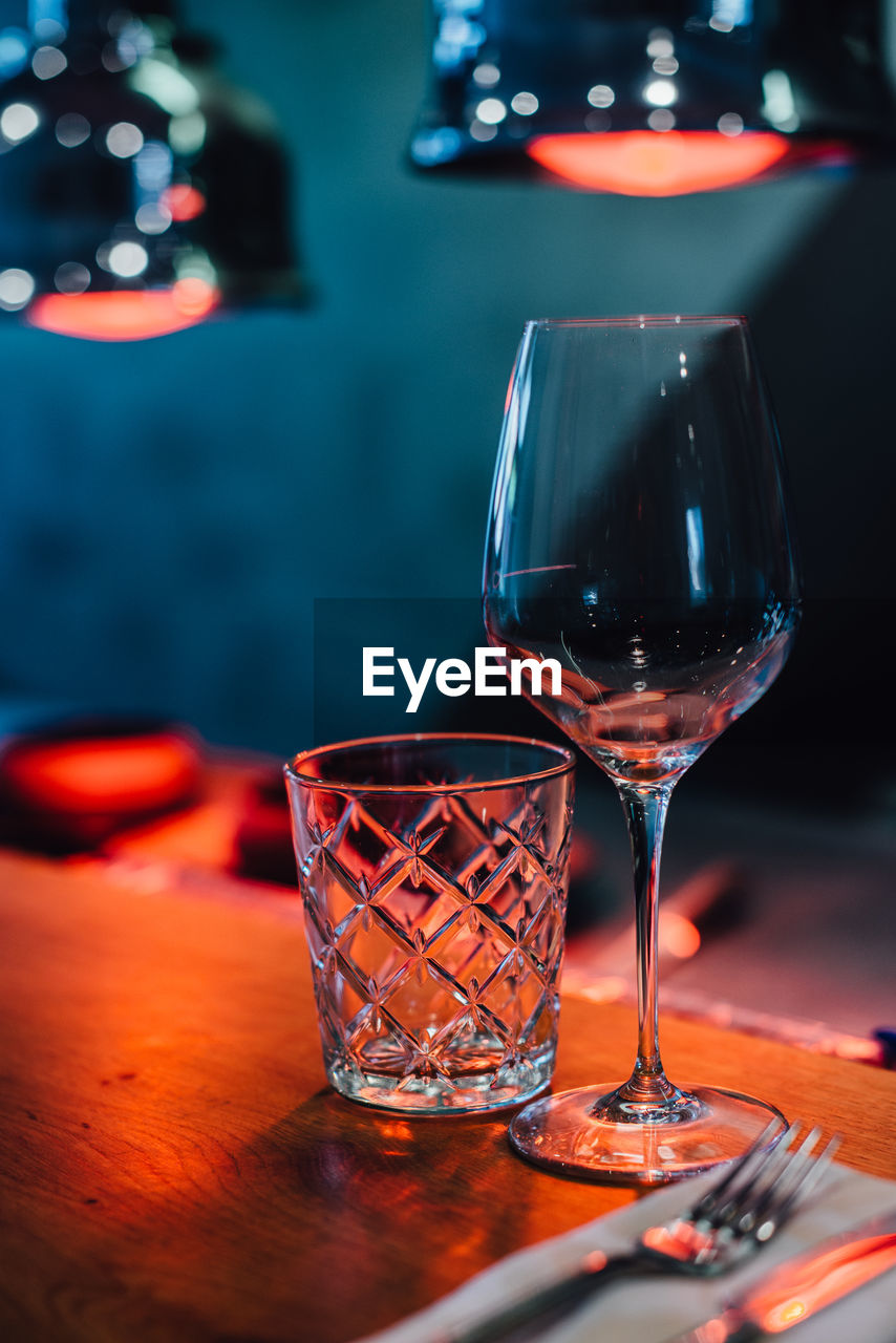 Glasses on the table in red light of infrared heat lamps in restaurant