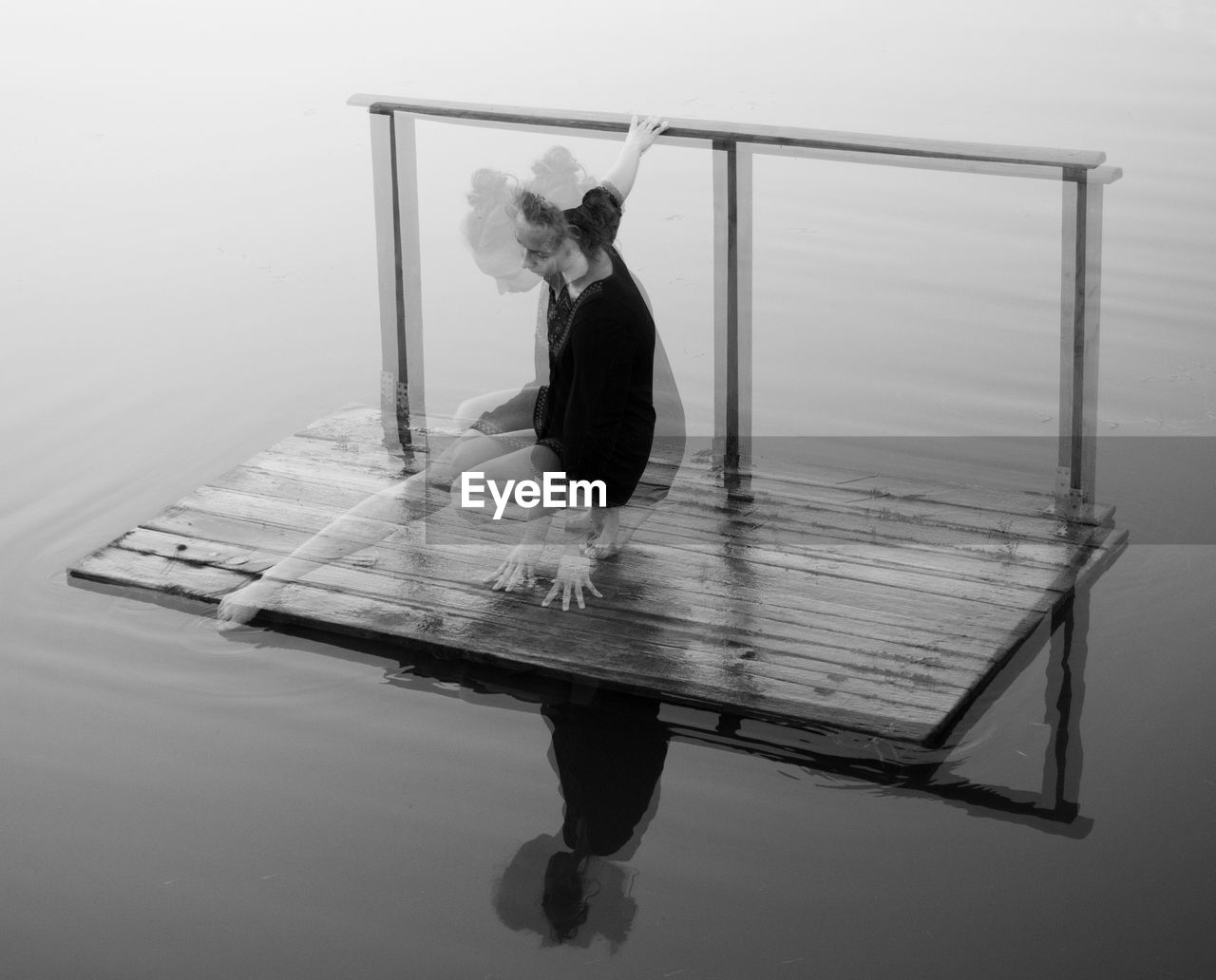 Double exposure of woman on floating platform in lake