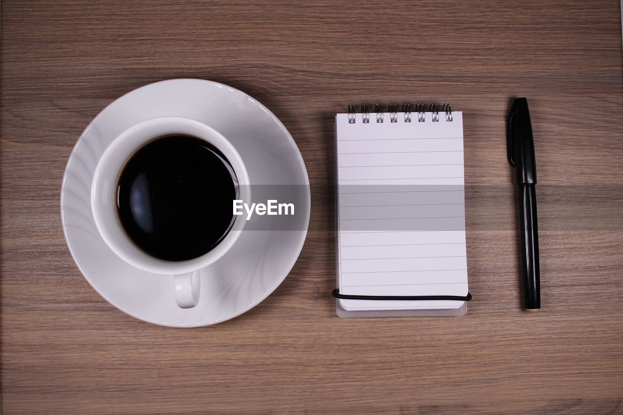 HIGH ANGLE VIEW OF COFFEE ON TABLE WITH BLACK AND WHITE BACKGROUND