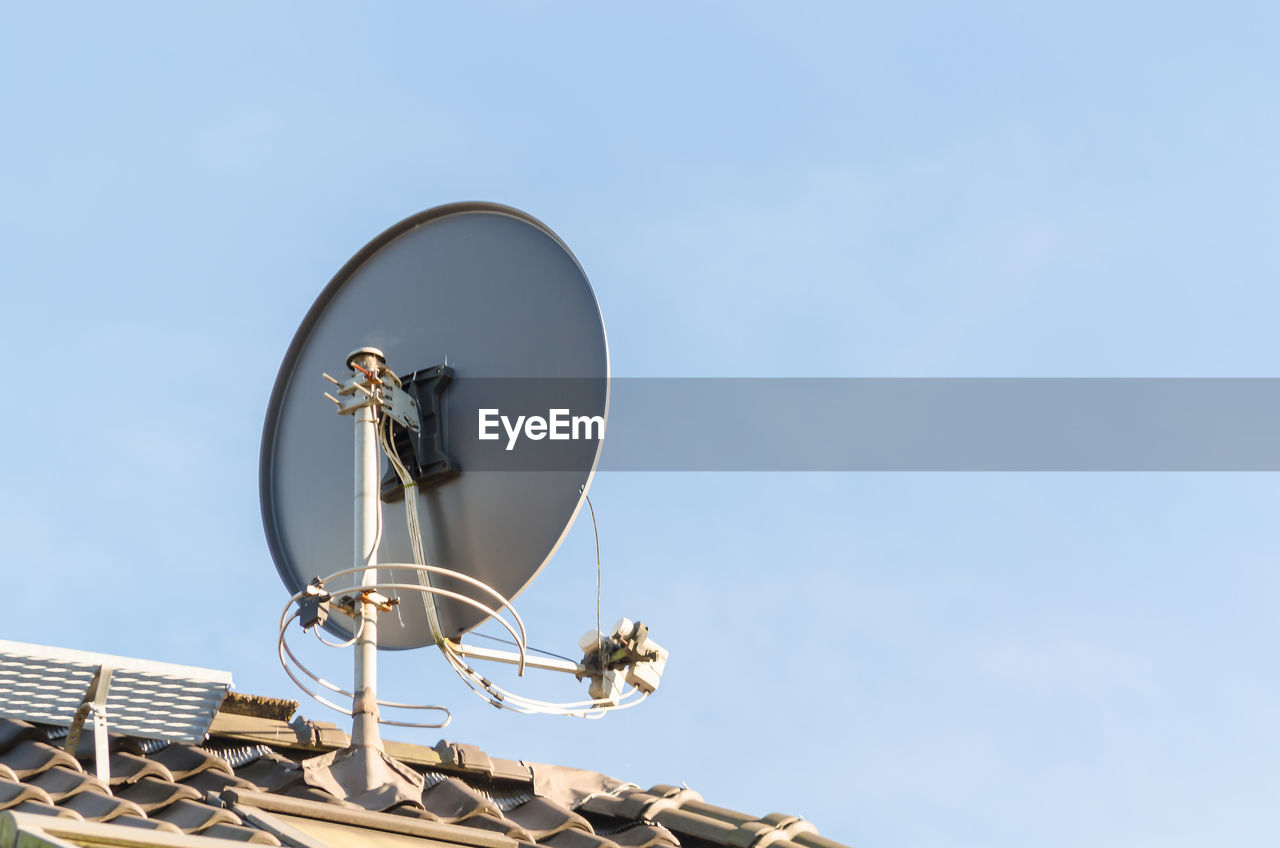 Low angle view of satellite dish on roof against clear sky