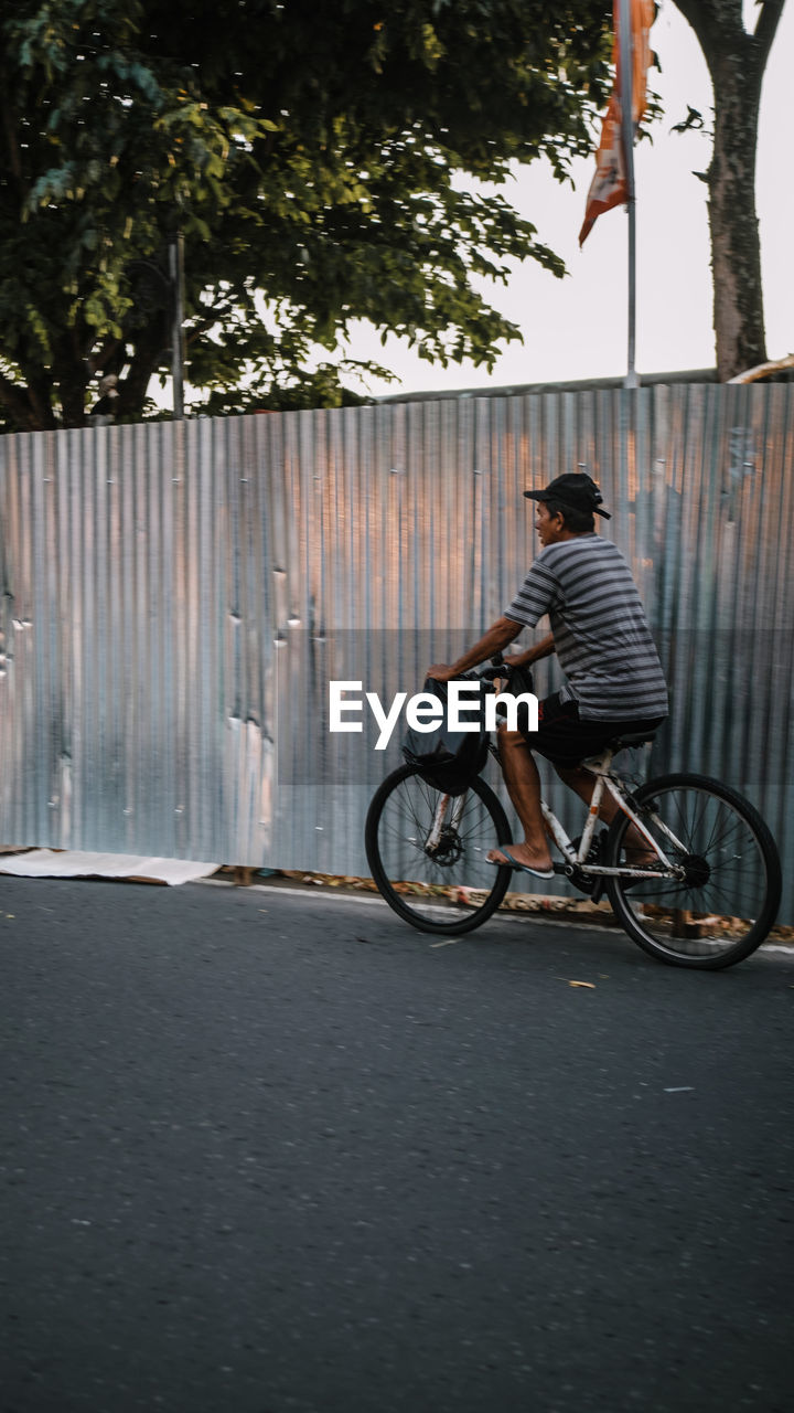 MAN RIDING BICYCLE ON ROAD