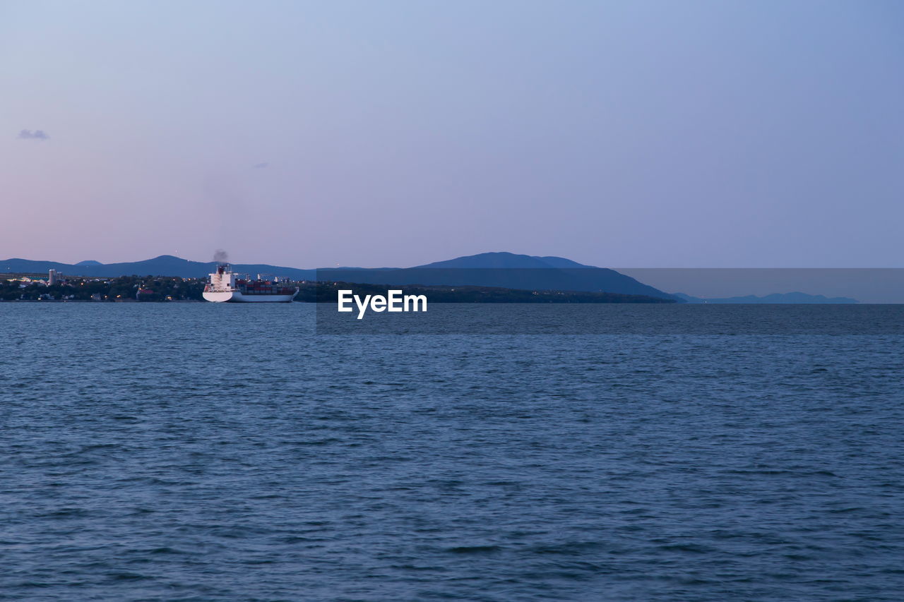 East view of the st. lawrence river with large cargo ship seen at sunset