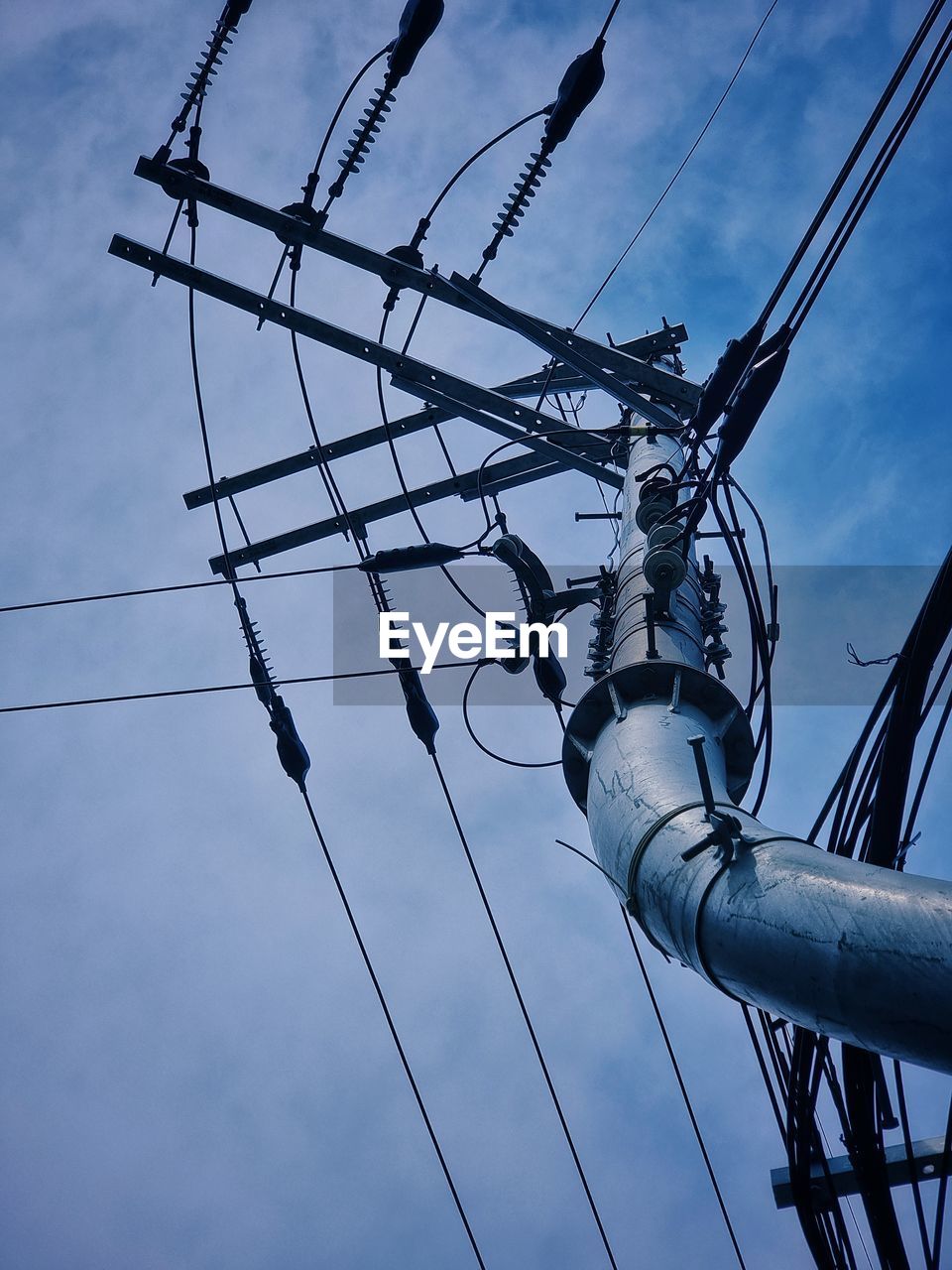 electricity, cable, blue, electrical supply, overhead power line, technology, sky, line, electricity pylon, power supply, power line, mast, power generation, cloud, outdoor structure, low angle view, transmission tower, no people, complexity, nature, communication, outdoors