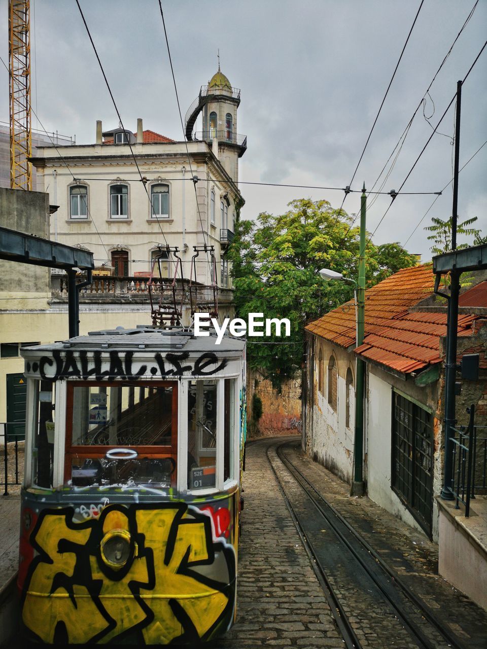 STREET BY BUILDINGS AGAINST SKY