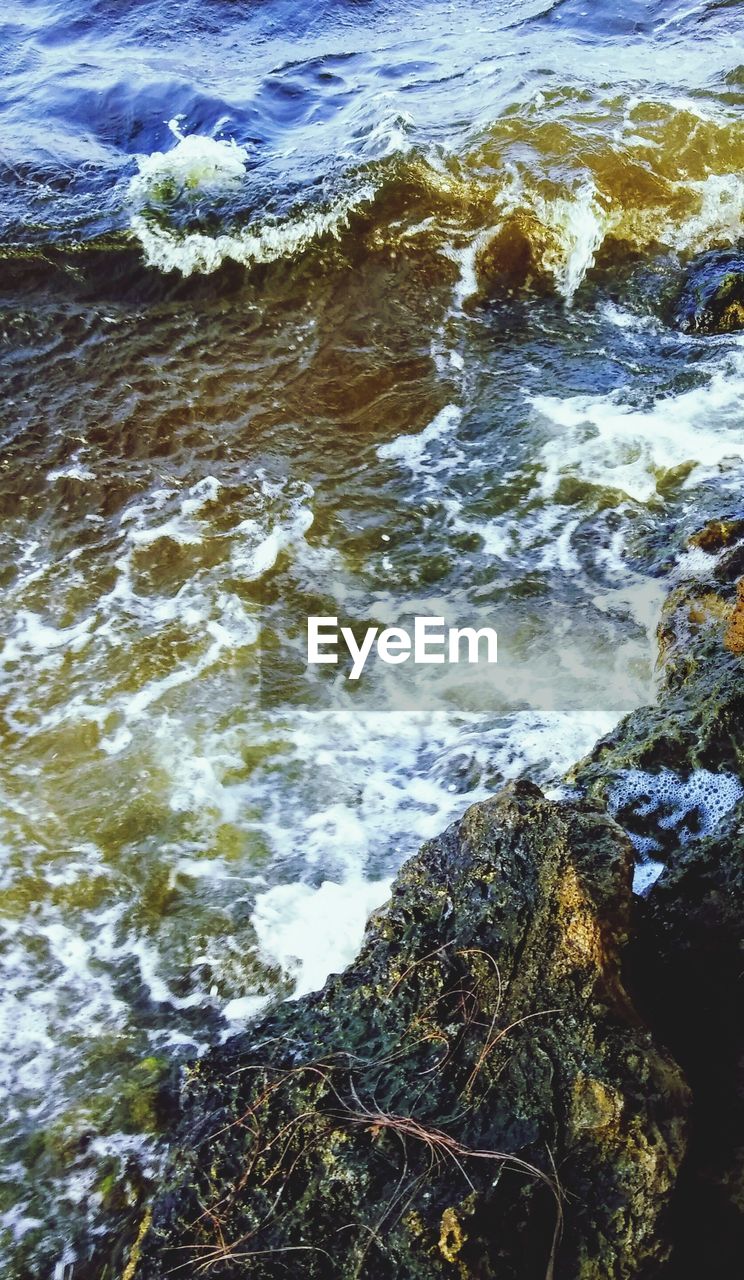 HIGH ANGLE VIEW OF ROCKS ON SEA