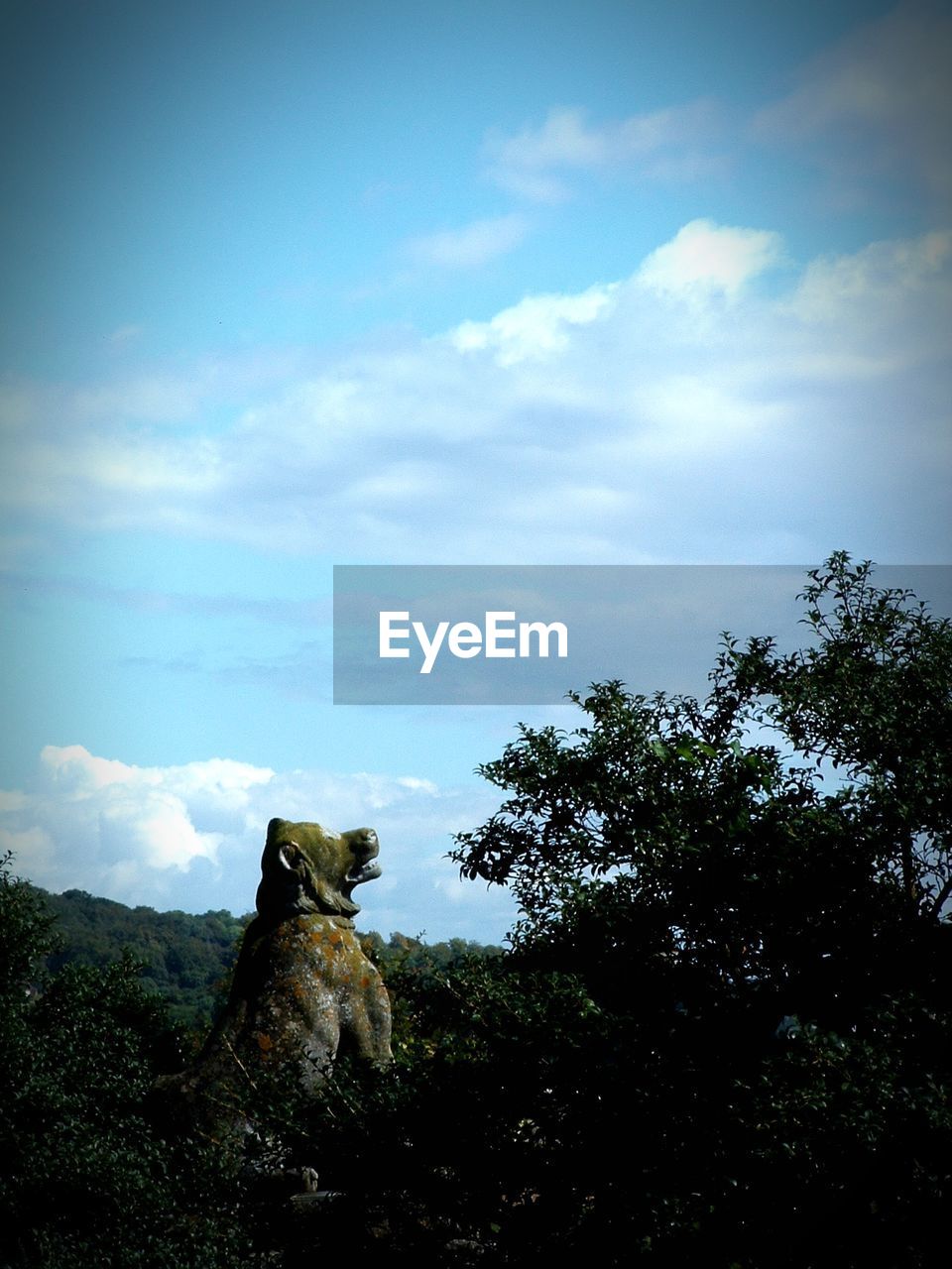 Statue amidst trees against sky