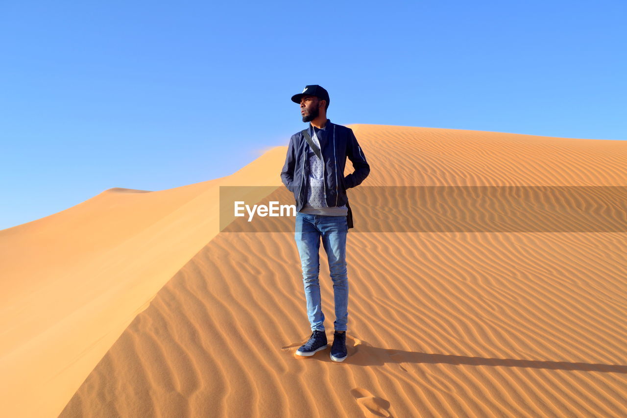 FULL LENGTH OF MAN STANDING ON DESERT