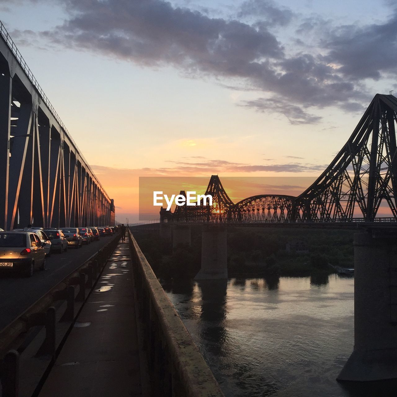 Bridge over river against cloudy sky