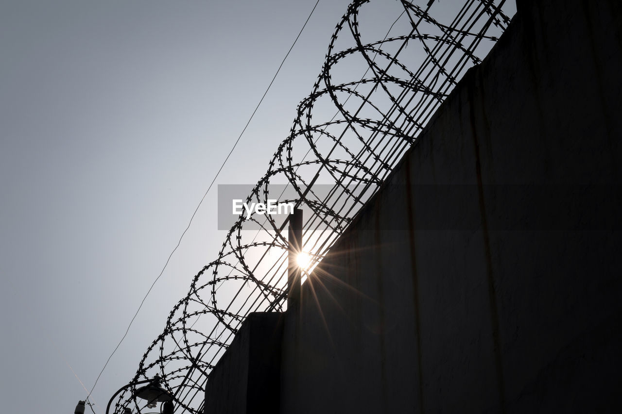 LOW ANGLE VIEW OF METAL FENCE AGAINST SKY