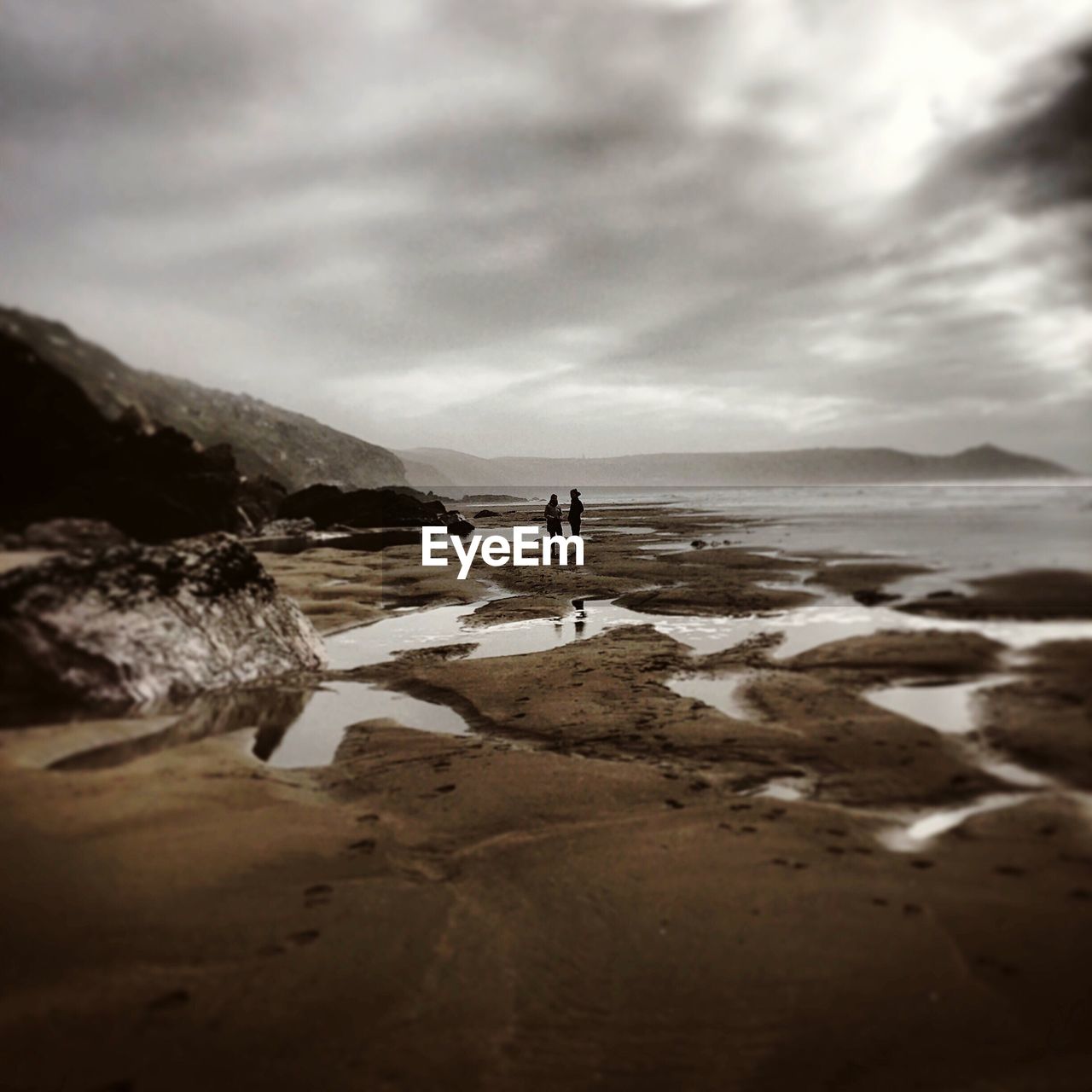 MAN STANDING AT BEACH AGAINST SKY