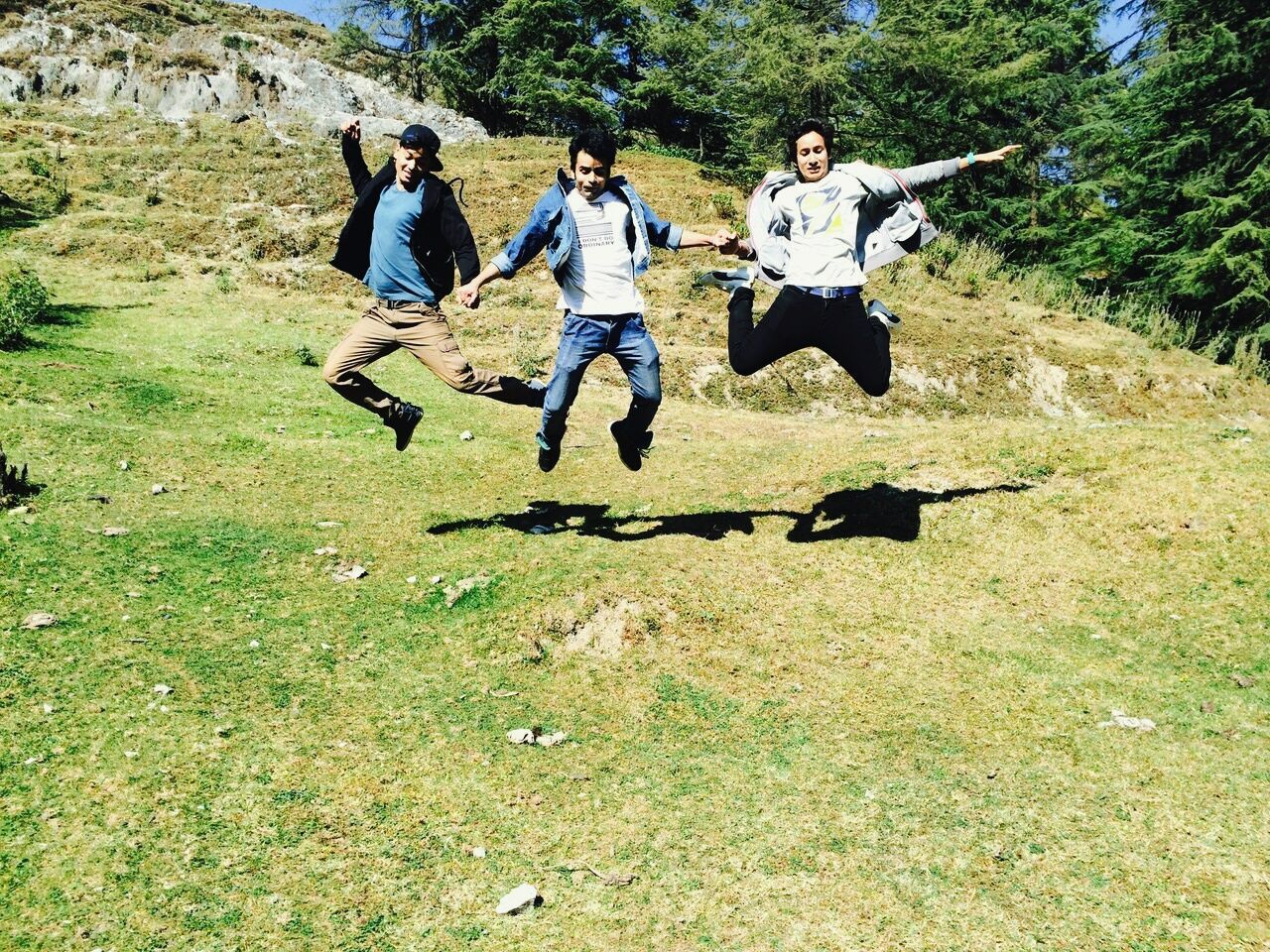 HIGH ANGLE VIEW OF PEOPLE JUMPING ON GRASS