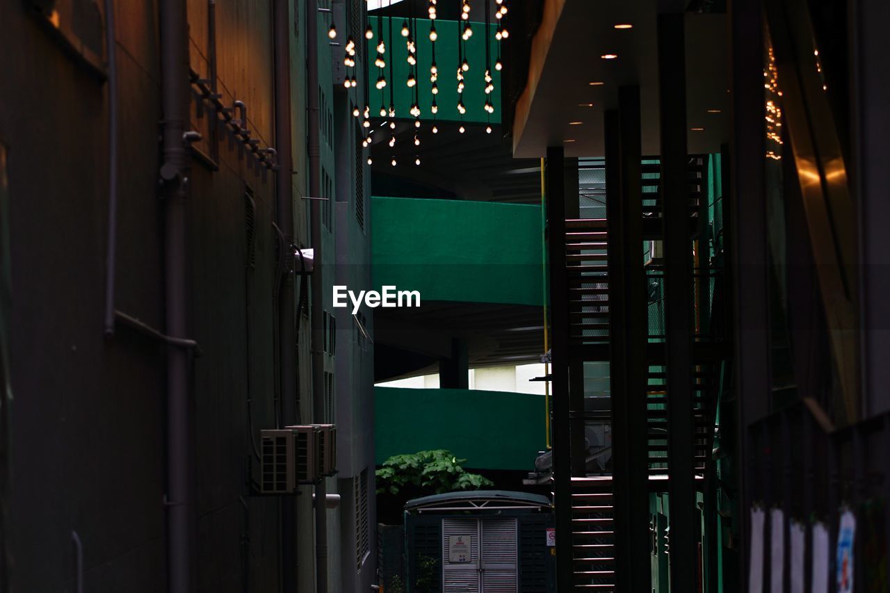 LOW ANGLE VIEW OF ILLUMINATED BUILDING AT ENTRANCE