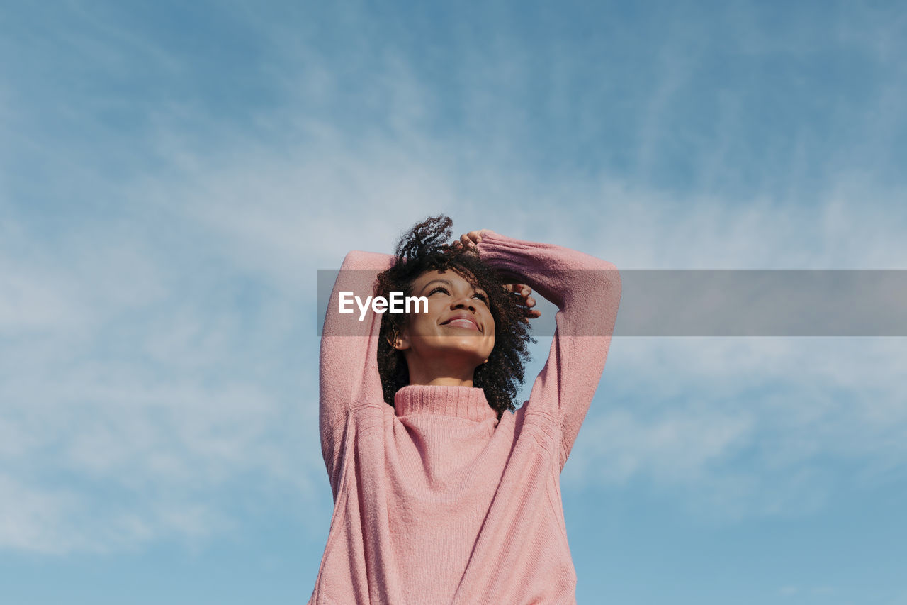 Portrait of happy young woman enjoying sunlight