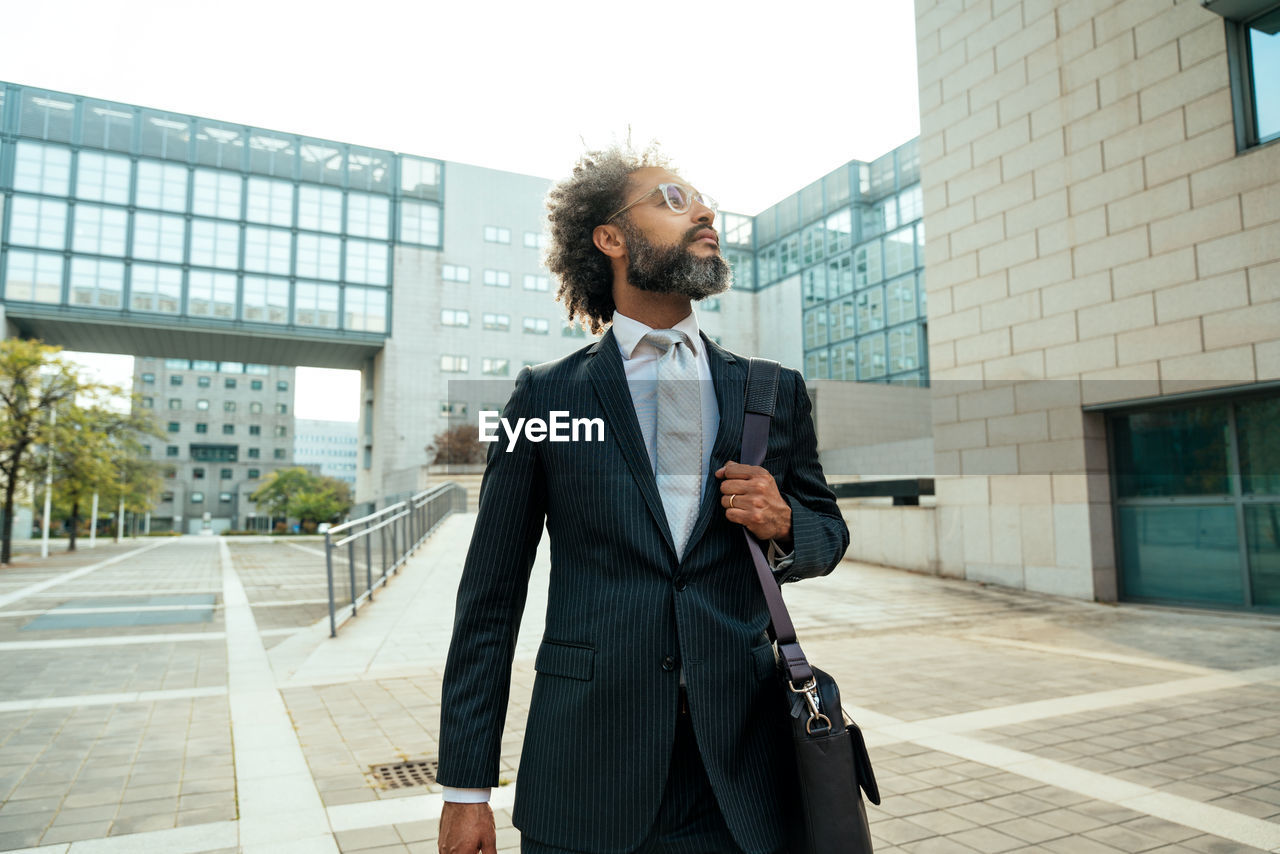 side view of young man standing against building