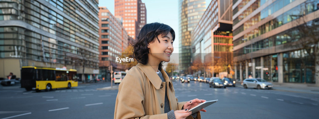 side view of young woman standing in city