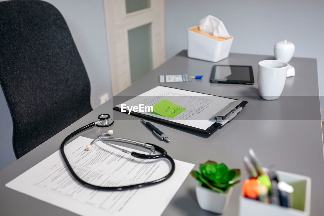 Doctor desk with medical documents and stethoscope