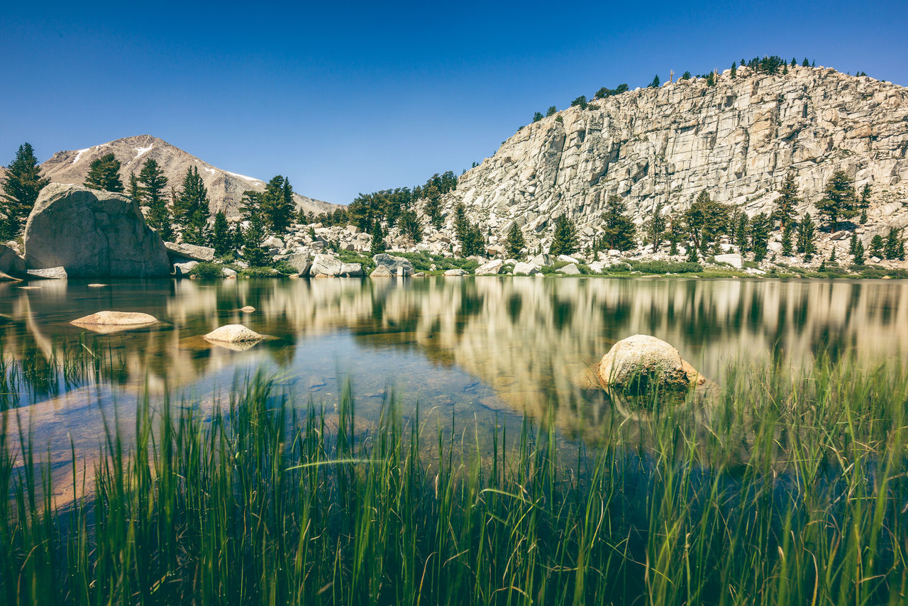 Scenic view of lake against clear blue sky