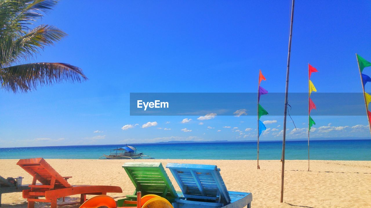 Scenic view of beach against blue sky