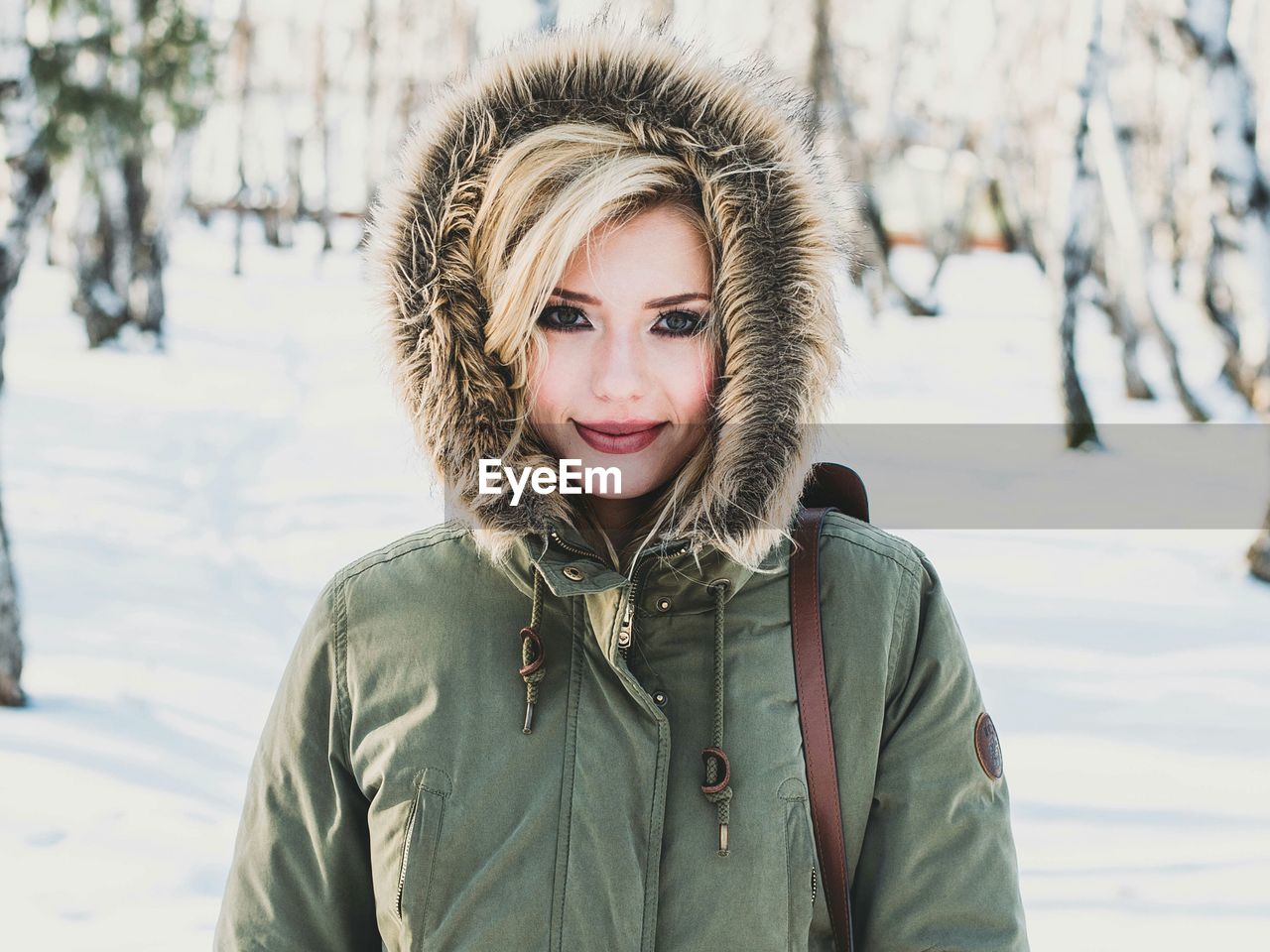 Portrait of smiling young woman in snow