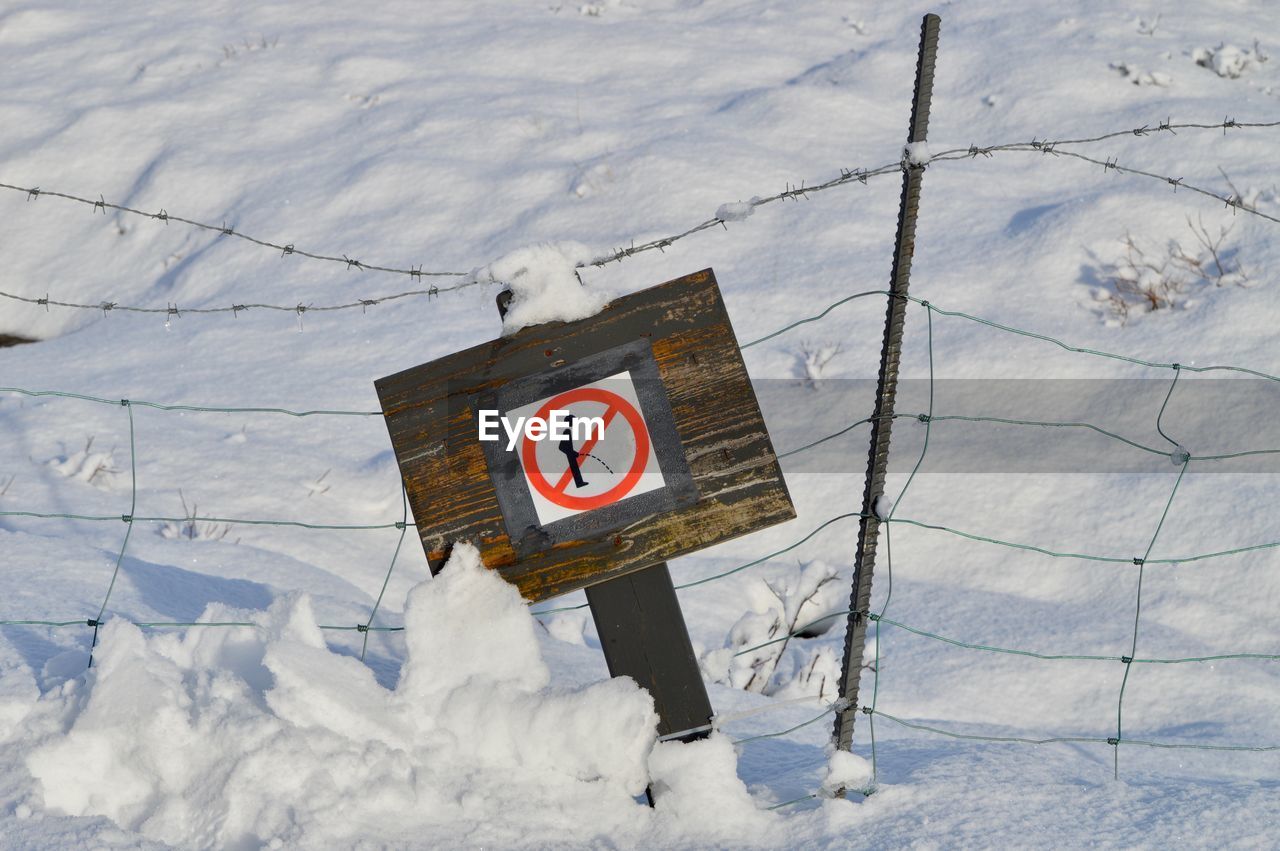 High angle view of road sign on snow covered land