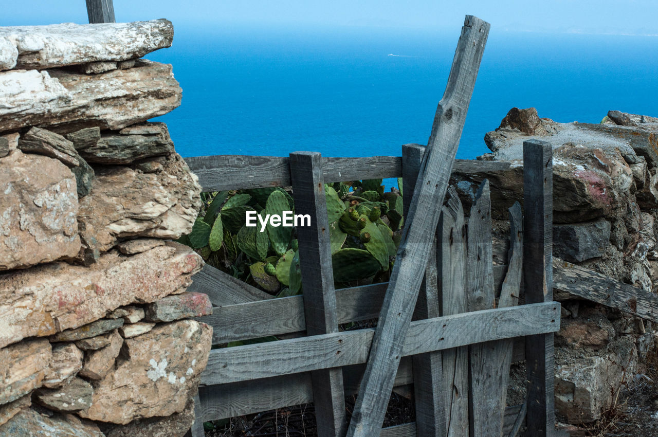 STONE WALL BY SEA AGAINST BLUE SKY