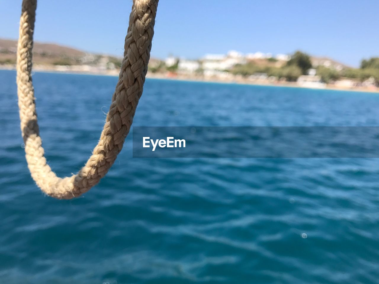 CLOSE-UP OF ROPE ON SEA AGAINST CLEAR SKY